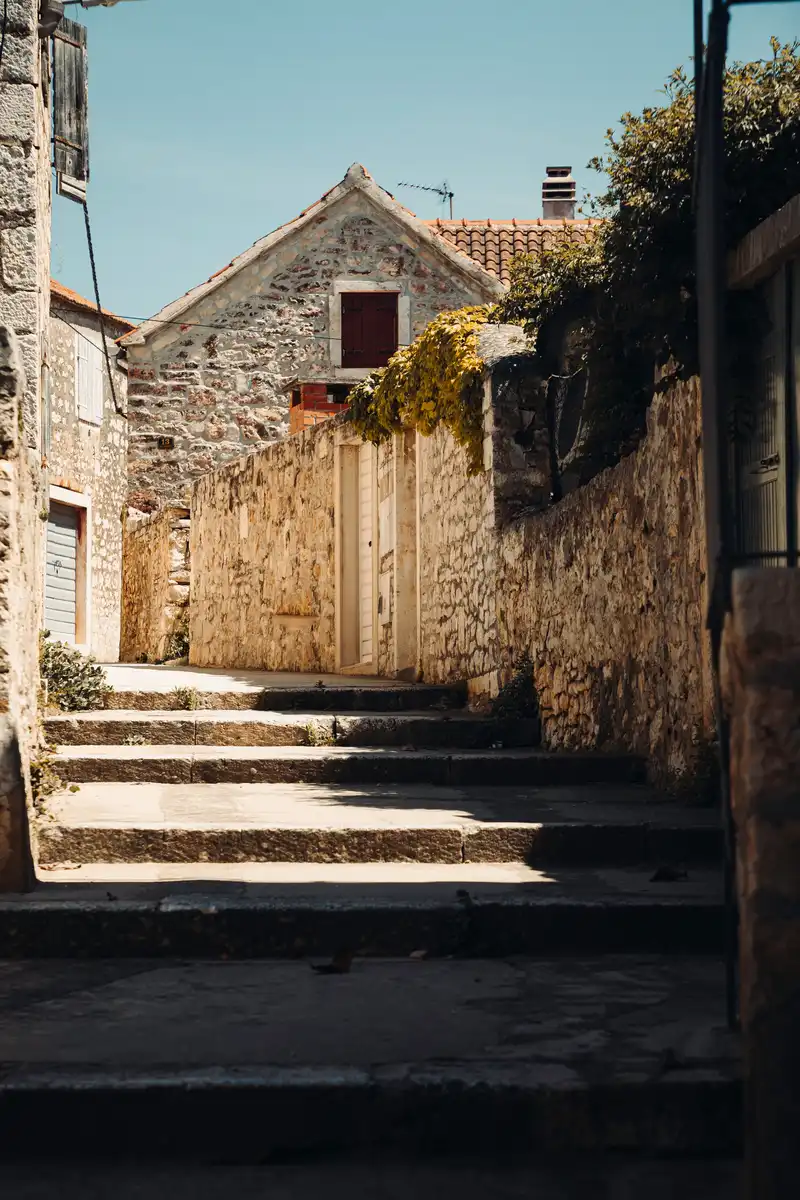 Narrow stone alley with traditional limestone houses in a village on Brač