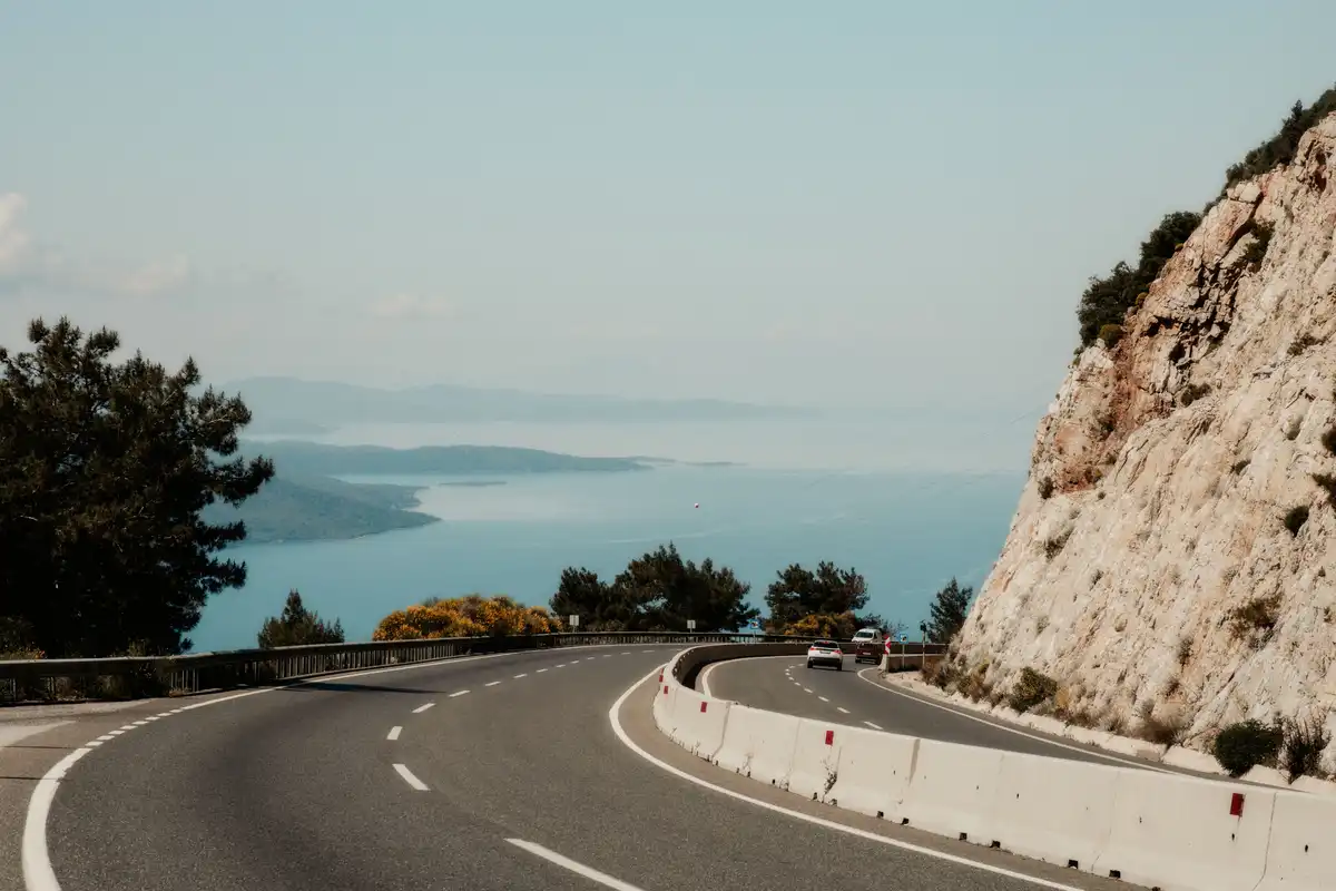 Cars travelling along a scenic coastal road overlooking the Adriatic Sea in Croatia