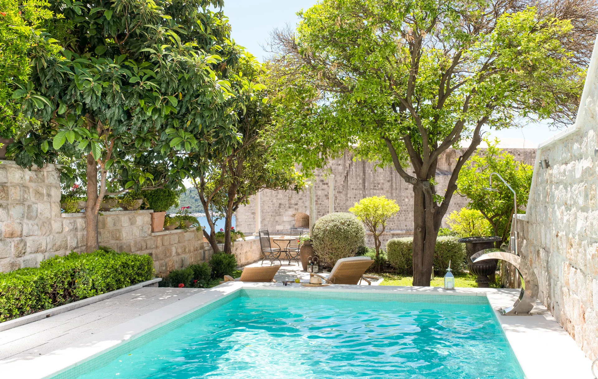 Private pool and garden at Villa Muri di Dubrovnik beside the Old Town city walls, with a sea view through the trees