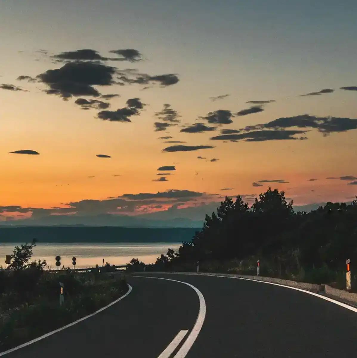 Empty coastal road beside the Adriatic Sea at sunset in Croatia