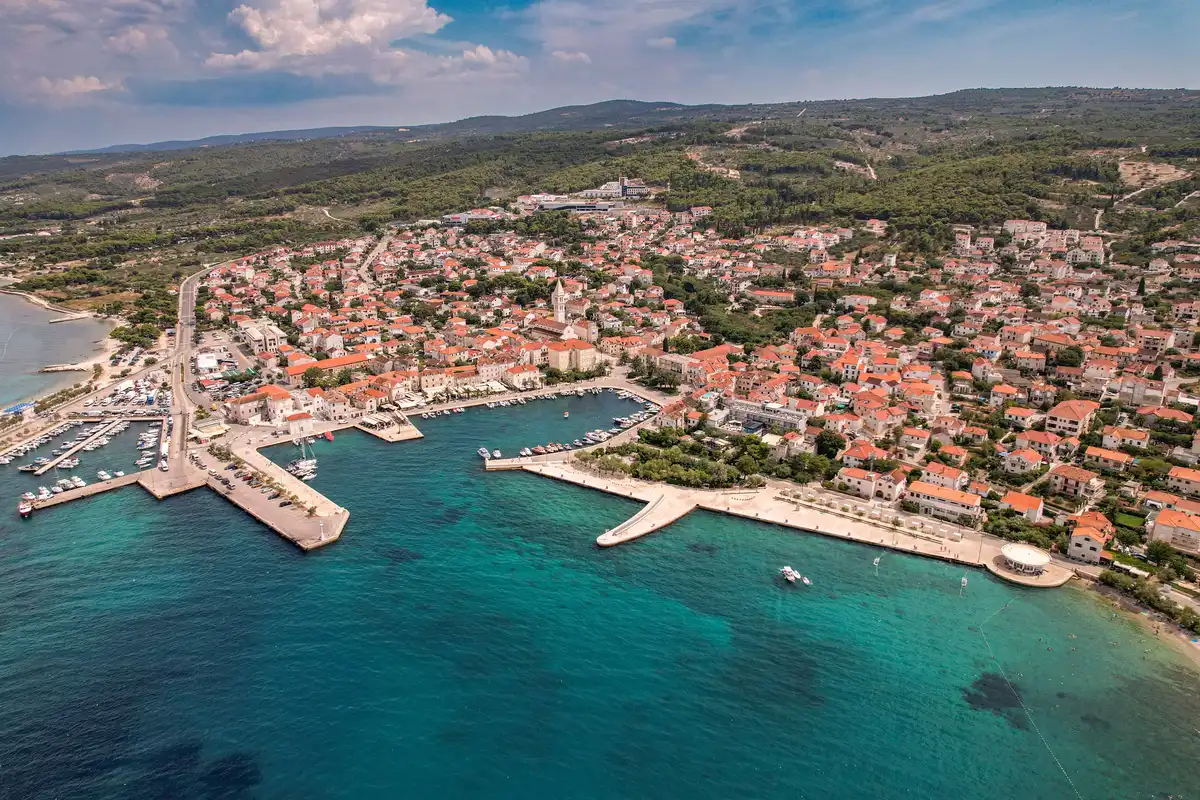 Aerial view of Supetar, Brač's main ferry port town with harbor, shops and beaches
