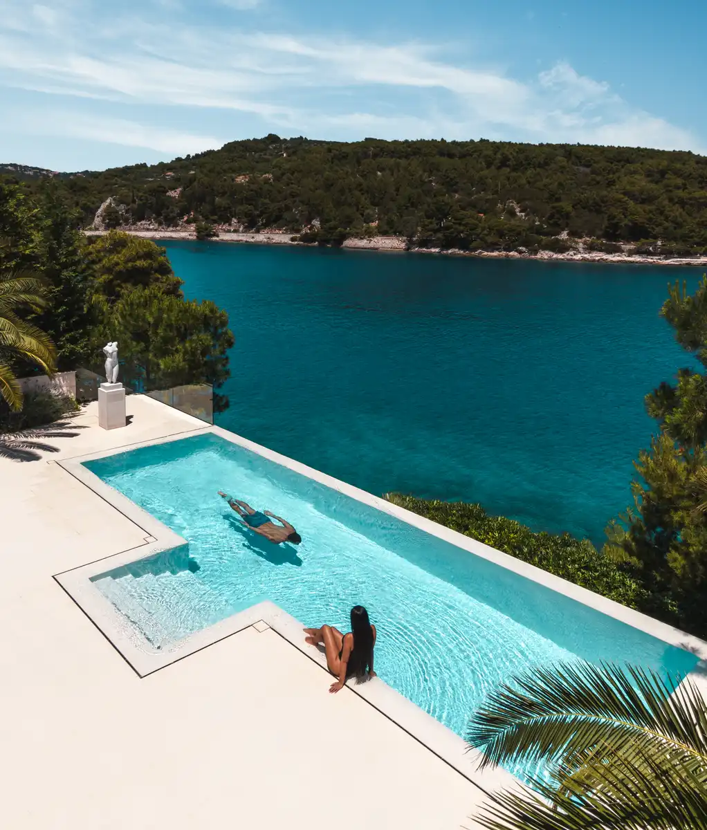 Guests relaxing in an infinity pool overlooking the sea at Villa Neptun, Brač