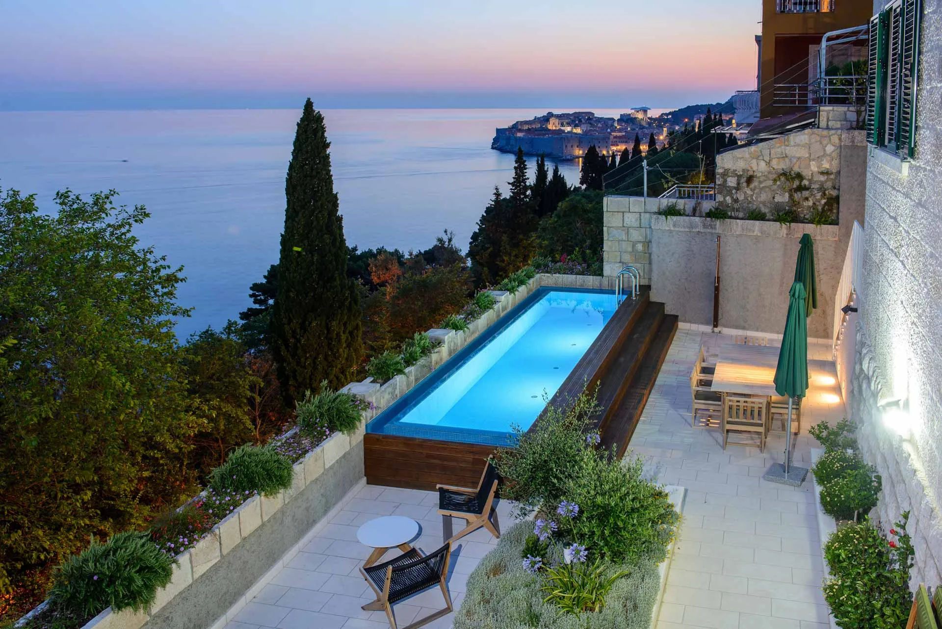 Elevated pool terrace at sunset with panoramic view over Dubrovnik Old Town, city walls and Lokrum Island, from Villa Grande Bellezza in Ploče
