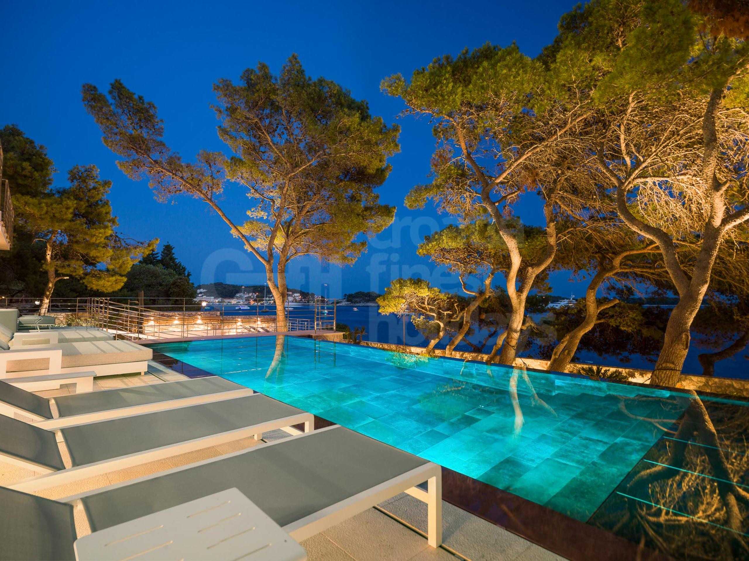 The overflow heated swimming pool of a luxurious Croatian holiday villa next to the beach on Hvar