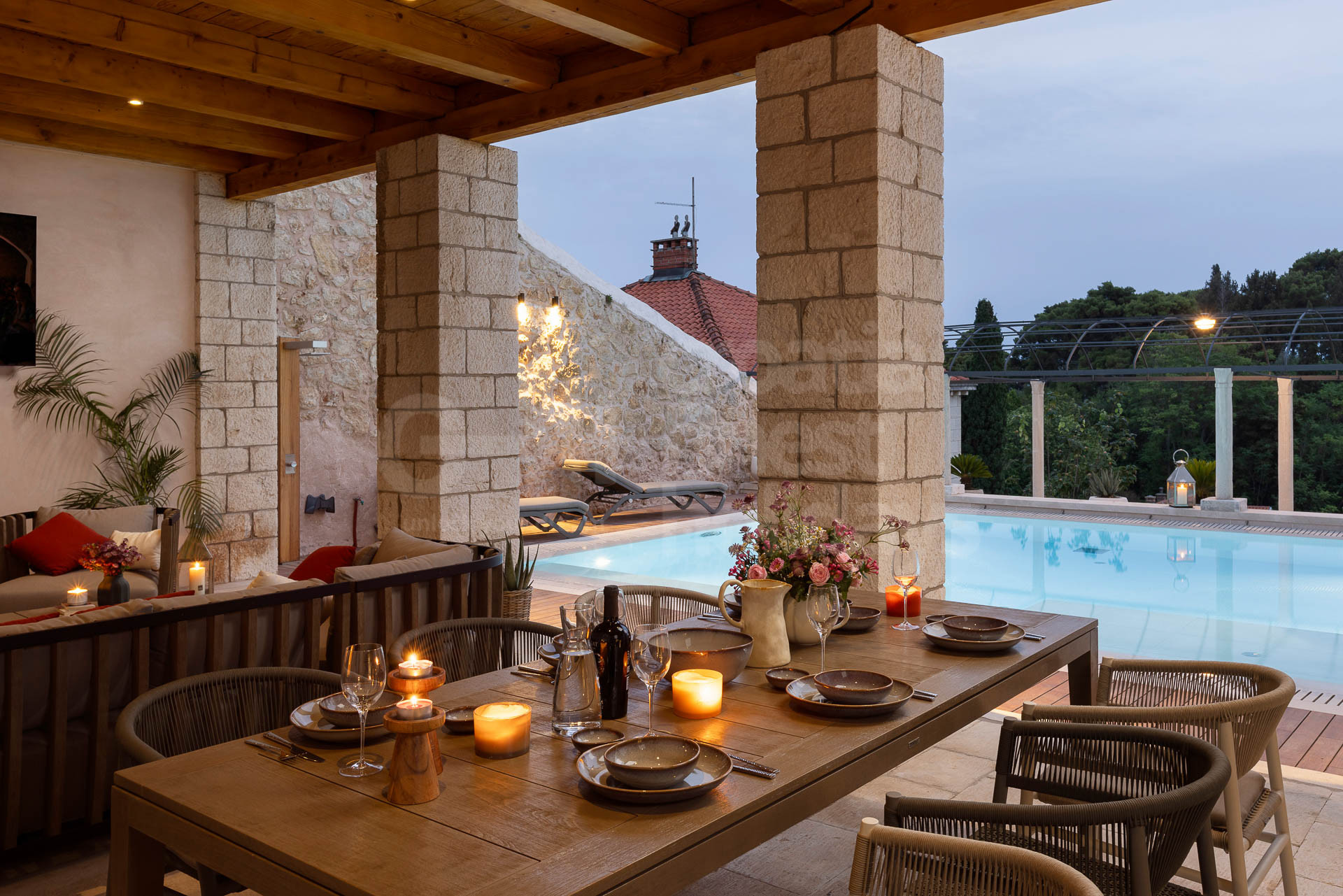 Outdoor dining area by the heated swimming pool in modern Villa Bloom