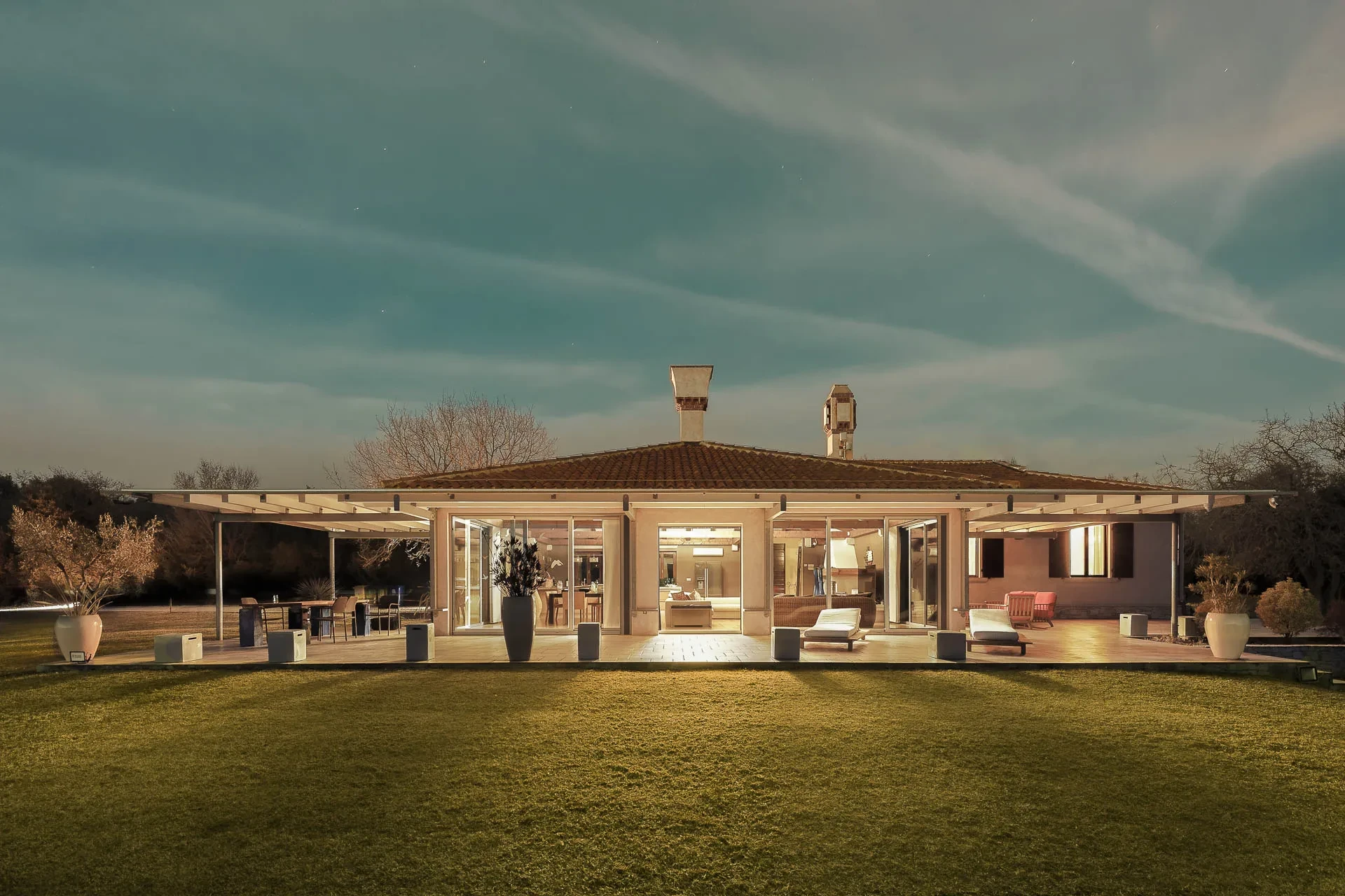 Rubini Estate in Rovinj features a house surrounded by a large lawn and an expansive patio area.
