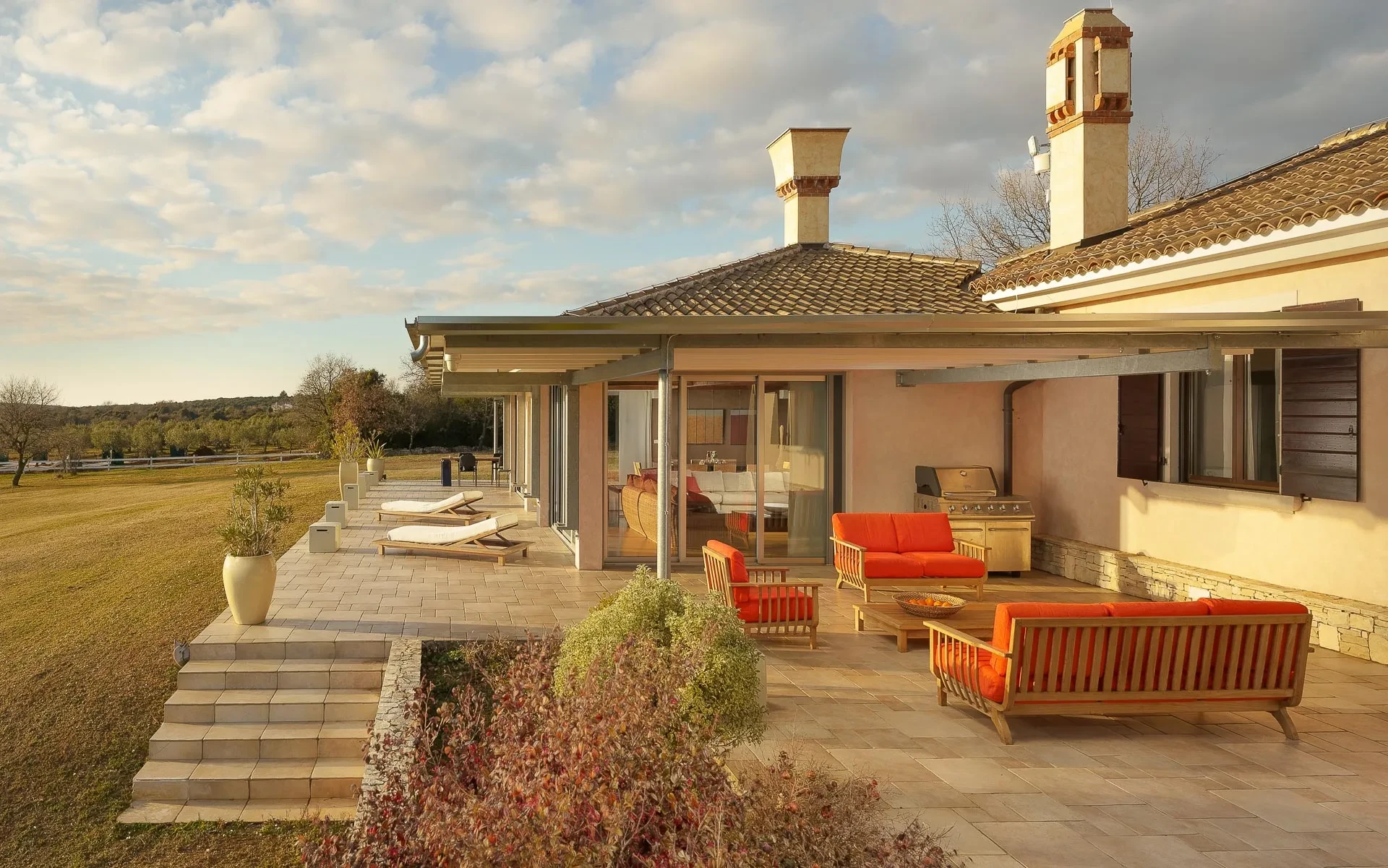 A patio at Rubini Estate Rovinj featuring a table and chairs, surrounded by greenery and a serene atmosphere.