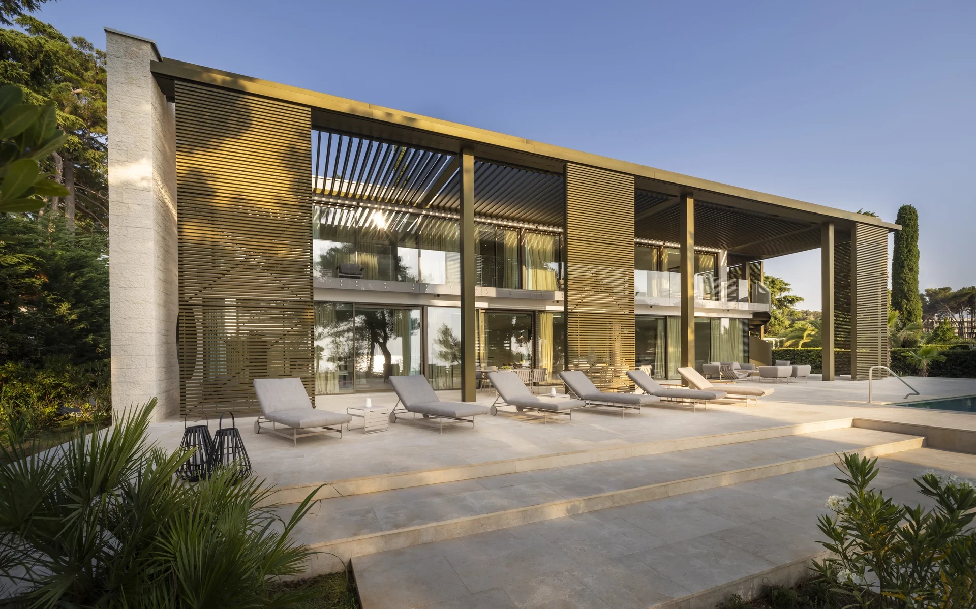 Modern Villa Lani in Poreč, Istria, features a serene pool surrounded by lush trees, perfect for a relaxing getaway.