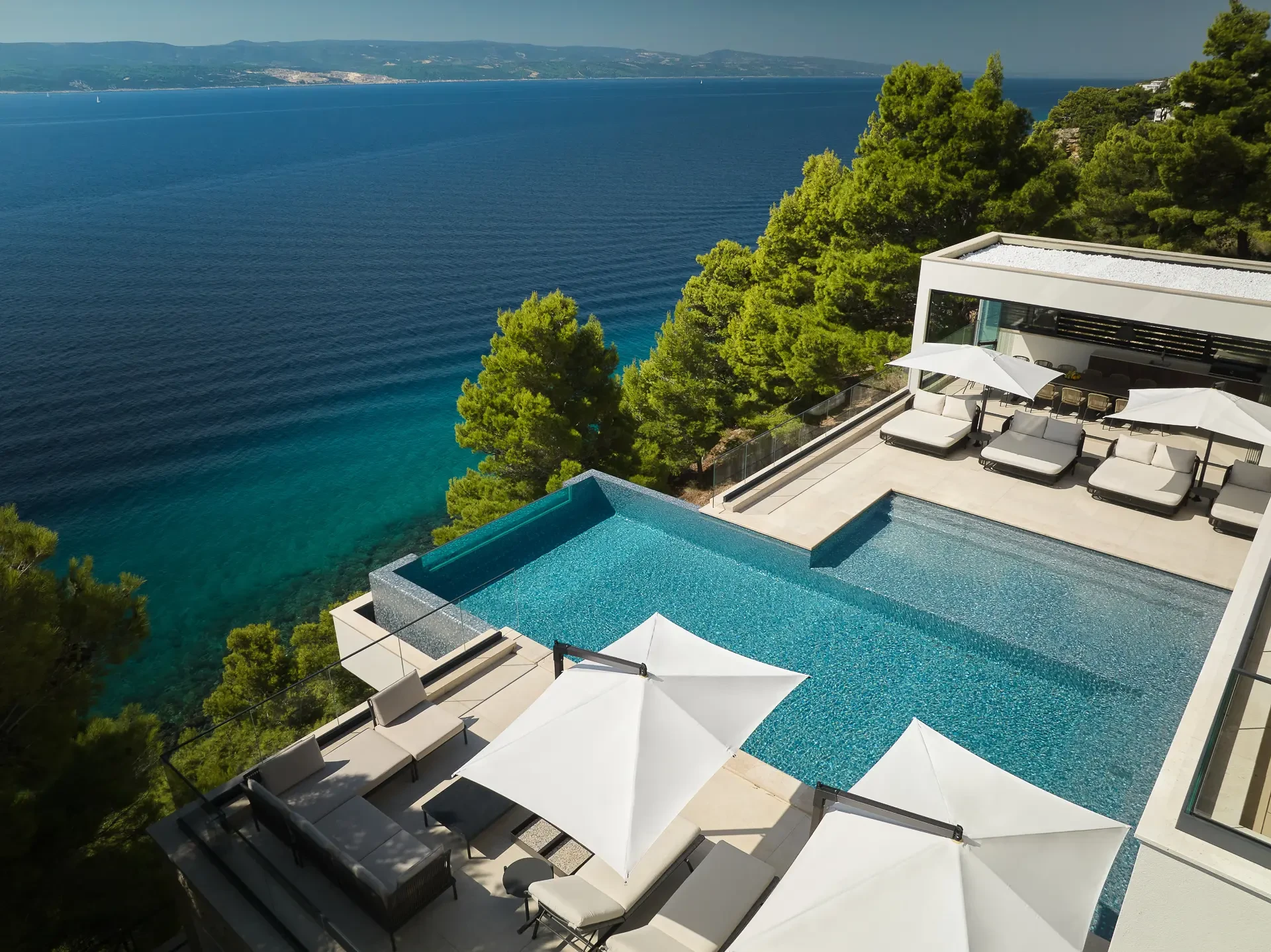 Private heated infinity pool with sun loungers in luxury rental villa Muse in Mimice