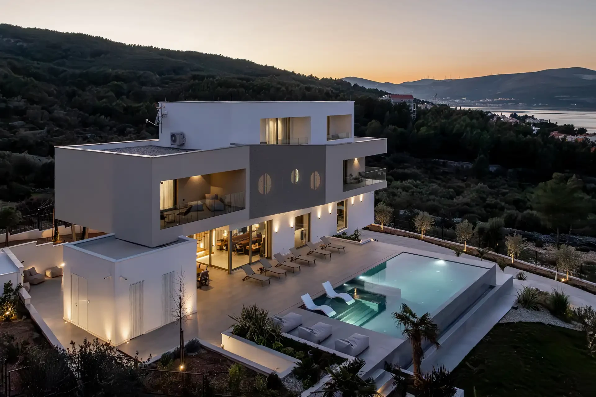 Night view of luxury five bedroom villa with heated illuminated pool, sea view and garden