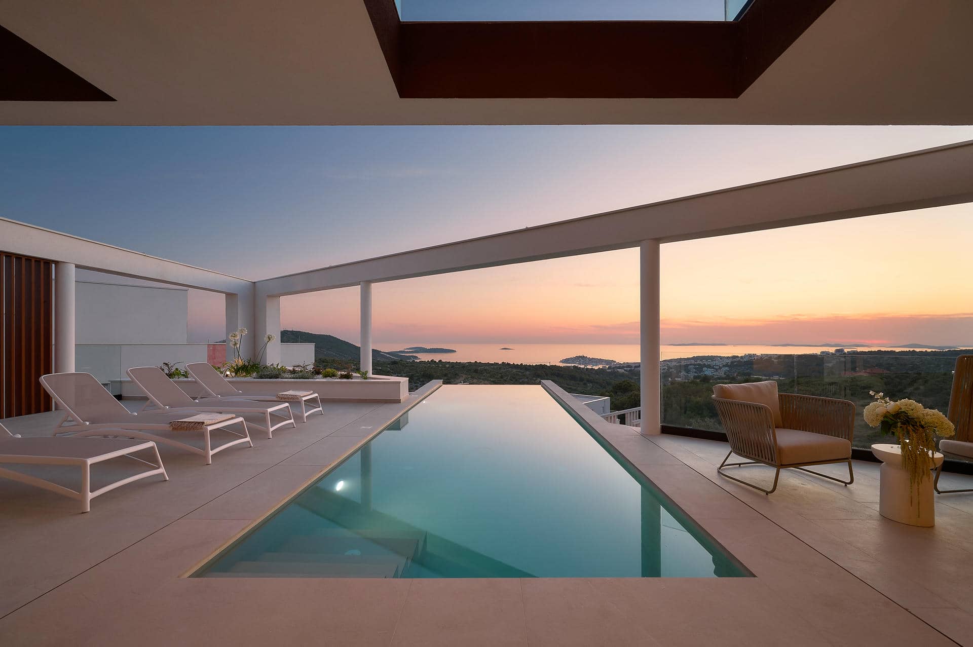 Villa Serena features a beautiful pool and lounge chairs with panoramic sea views, ideal for a peaceful holiday in Primosten.