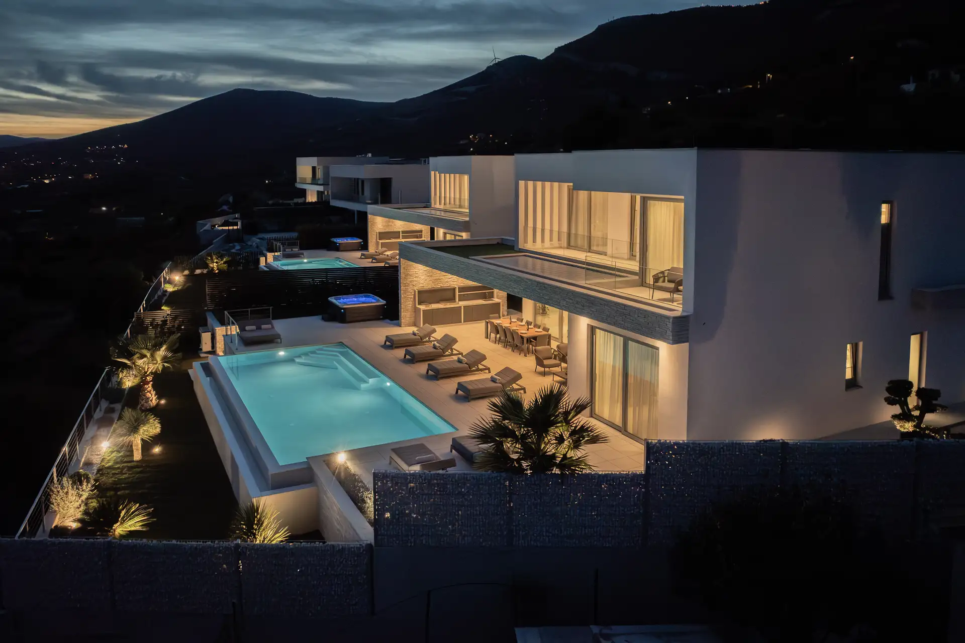 Modern villa at night featuring a serene pool, perfect for luxury travel and relaxation under the stars.