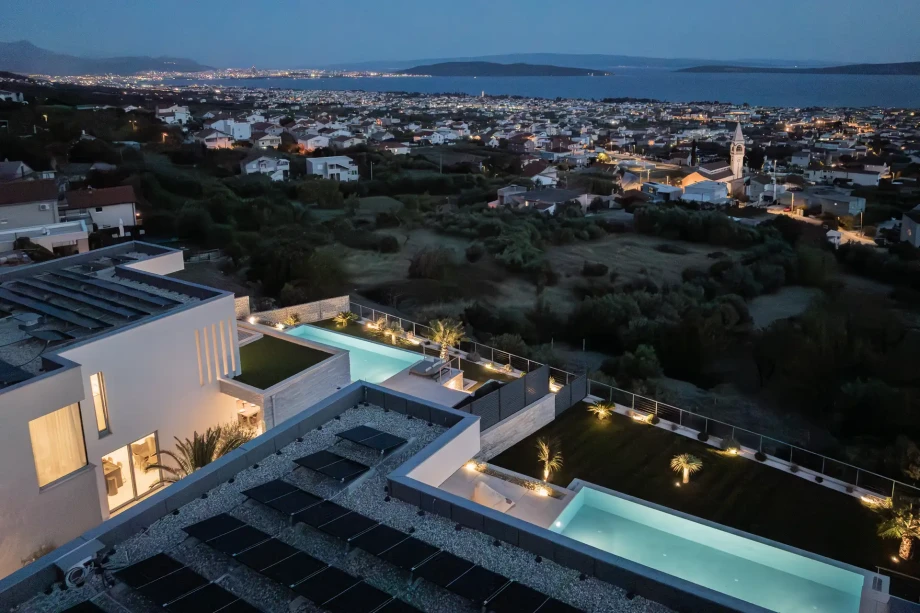 Contemporary villa featuring a pool and panoramic sea views, ideal for a relaxing beach vacation.