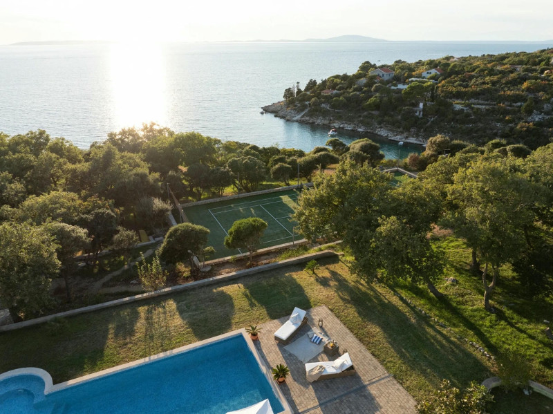 Aerial view of Villa Magran's pool overlooking the sparkling sea, showing a serene coastal landscape