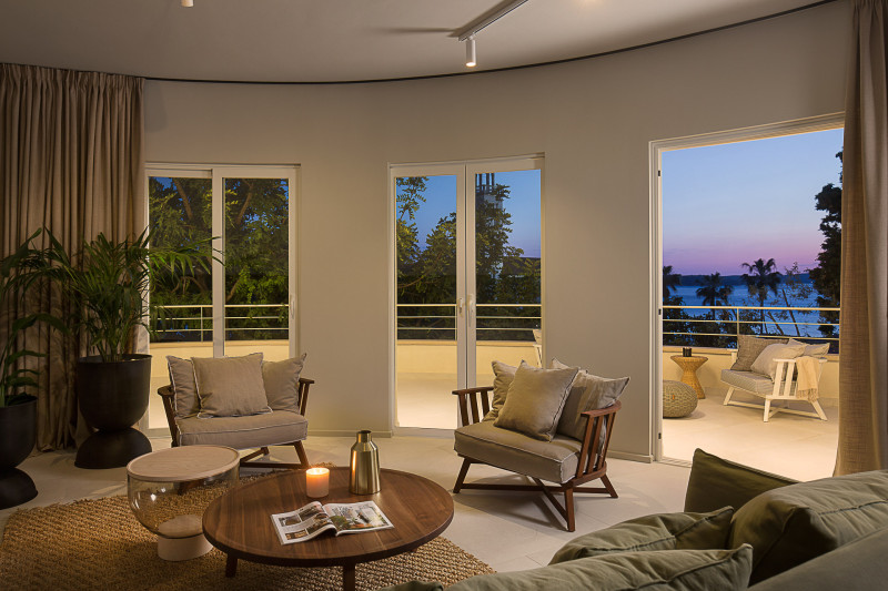 A cozy living room featuring large windows that showing a stunning sunset and view of the sea at Villa Teodora.