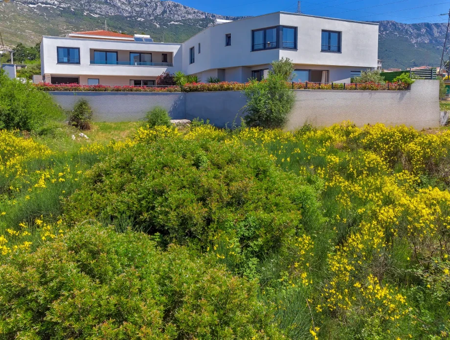 Contemporary Villa Adria in Kaštel Sućurac with landscaped grounds and mountain backdrop.