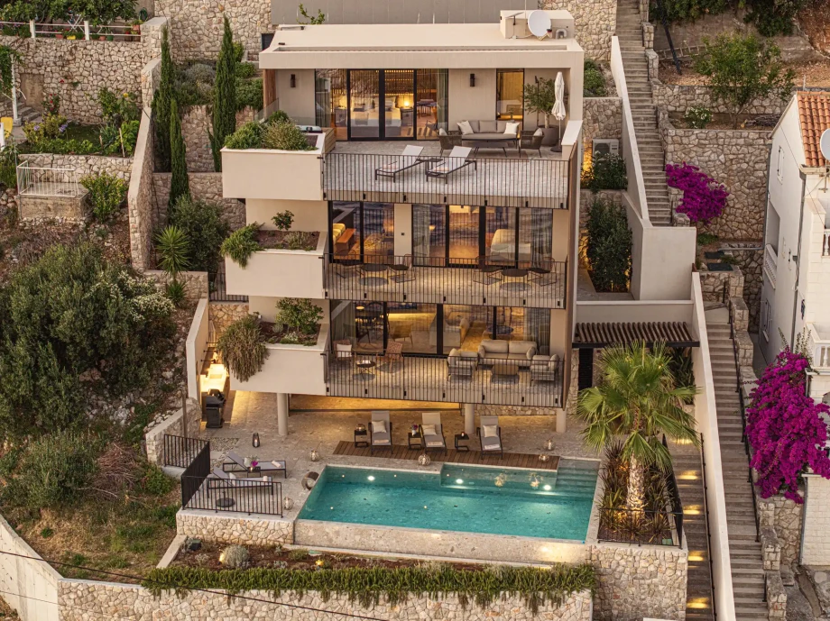 Exterior view of Villa Infinity Vista Dubrovnik with illuminated pool and multiple sea-view terraces.