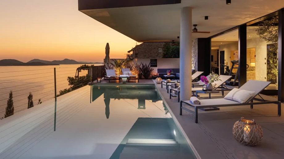 Private swimming pool with sun loungers and sea views.