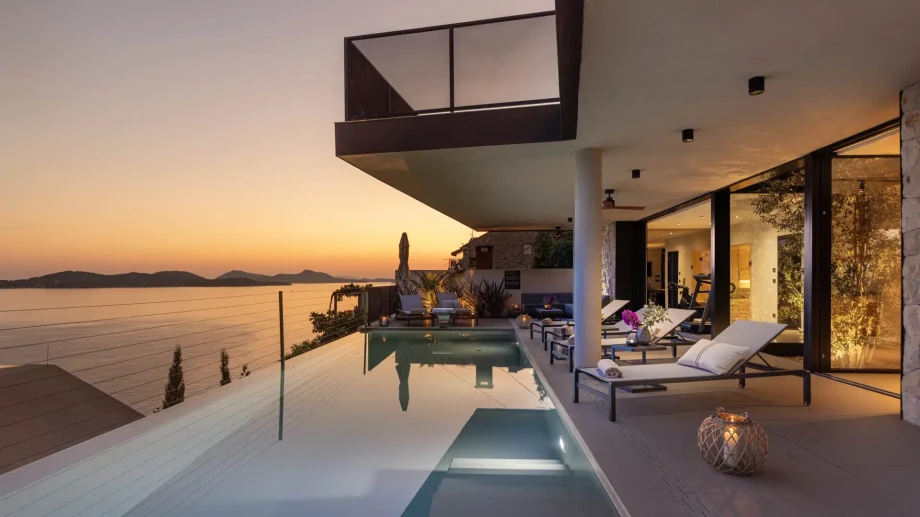 Infinity pool terrace wuth panoramic sea views at sunset.