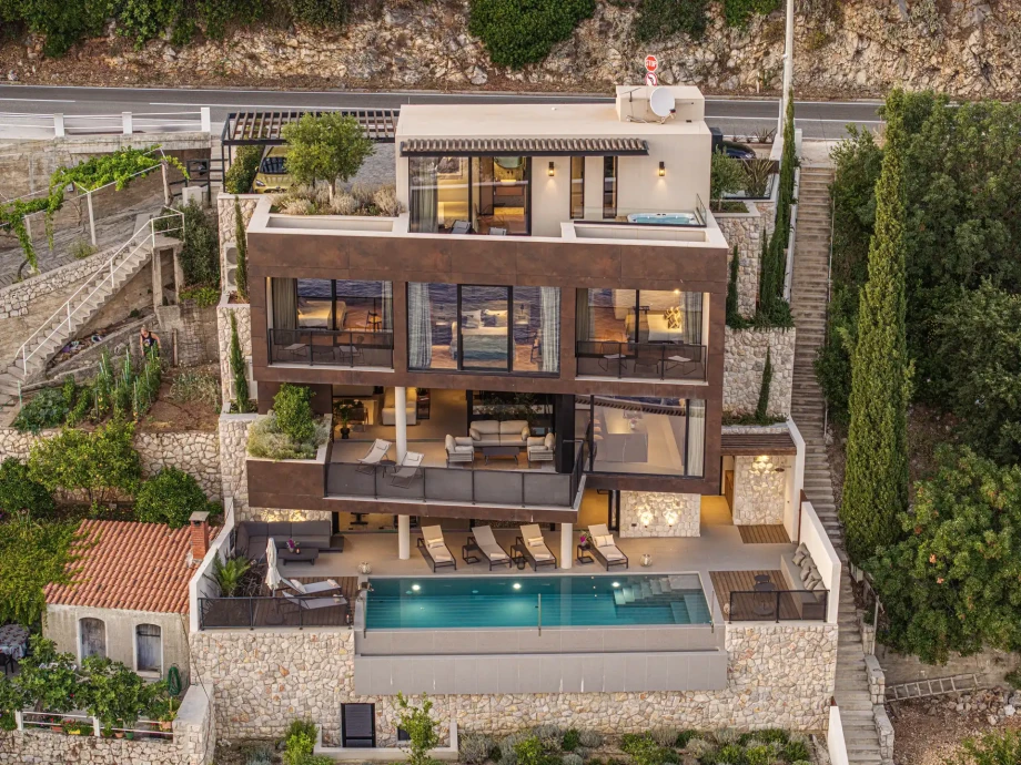 Front aerial view of Villa Riviera Retreat Dubrovnik and illuminated infinity pool.