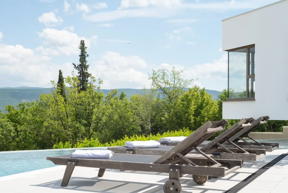 Bright pool terrace at Villa Imota Sapphire with comfortable sun loungers, modern architecture and open views across the countryside near Imotski