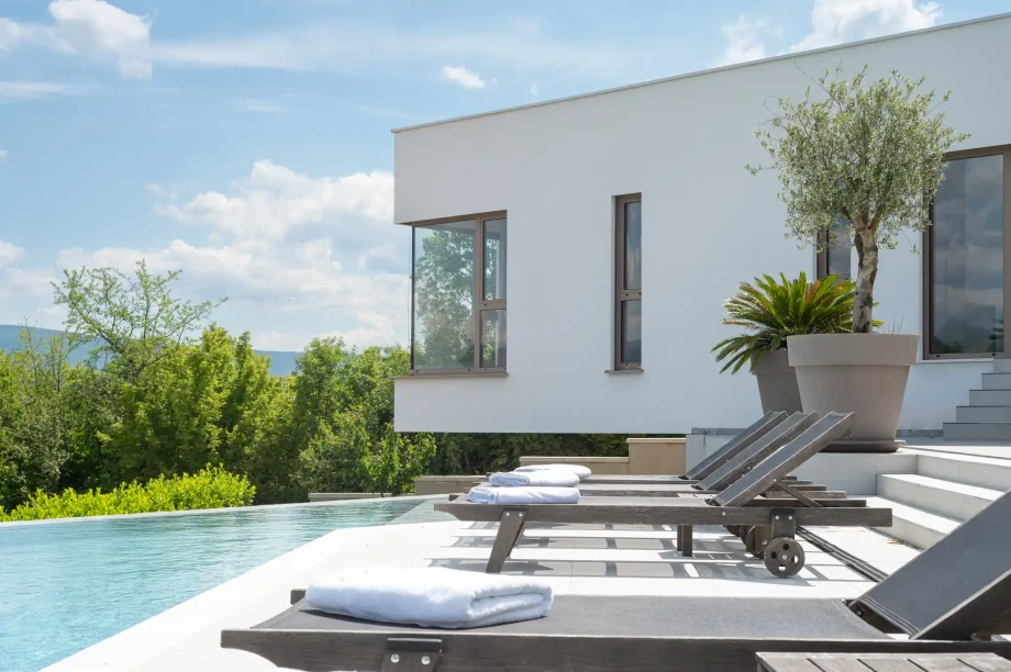 Villa Imota Sapphire's infinity pool and sun loungers with a countryside view near Imotski